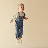 Child jumping wearing WILSON & FRENCHY Organic Denim Overall