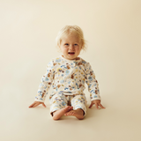 Baby sitting on floor wearing WILSON & FRENCHY Daisy Mae Organic Zipsuit With Feet