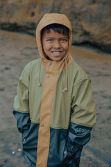 Detail view of child wearing CRYWOLF Explorer Jacket - Fern Colourblock - Green/Black/Tan raincoat