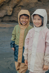 Detail view of 2 children wearing their raincoats. Boy on left wearing the CRYWOLF Explorer Jacket - Fern and the girl on the right is wearing CRYWOLF Explorer Jacket - Pink Colourblock