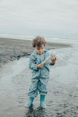 Child playing at beach wearing CRYWOLF Splash Suit - Stone Blue and matching rainboots