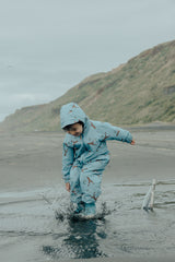 Child splashing in water at beach wearing the hood up on the CRYWOLF Splash Suit - Stone Blue
