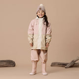 Studio shot of girl wearing CRYWOLF Explorer Jacket - Pink, Dusty Pink Rain Overalls and Dusty Pink Rain Boots
