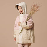 Studio shot of girl holding dry grass plants and wearing CRYWOLF Explorer Jacket - Pink