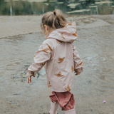 Side view of child wearing CRYWOLF Play Jacket Tui, Rosewood Rain Overalls and Dusty Pink Rain Boots