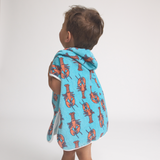Child wearing a blue towel with orange lobster patterns on a white background