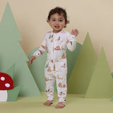Child wearing a forest-themed onesie with a bear and tree background