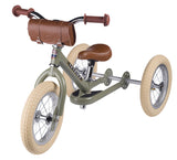 Children's tricycle with brown seat and handlebar bag on a white background