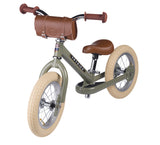 Children's balance bike with brown seat and handlebar bag on a white background