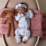 Baby lying in crib dressed in SNUGGLE HUNNY Kittens Organic Snugglesuit Convertible Romper and matching headband