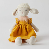 Stuffed toy sheep in a yellow dress on a white background