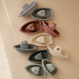 Set of colourful boat-shaped molds on a beige background