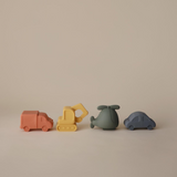 Set of four colourful bath toy vehicles on a beige background