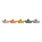 Five small toy boats in different pastel colors on a white background