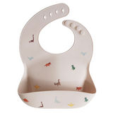 Baby bib with dinosaur print on a beige background