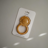 Silicone lion teether packaged in a white card with 'mushie' branding against a gray background