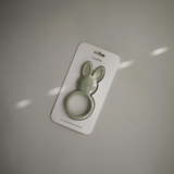 Green bunny-shaped teether packaged in a white card with 'mushie' branding against a light gray background