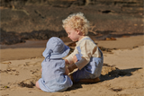 Two children playing in the sand on a beach.
