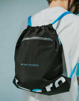 Black drawstring bag with 'we are mobility' text on a person against a light blue background