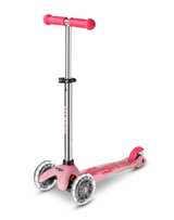 Pink scooter with silver accents on a white background