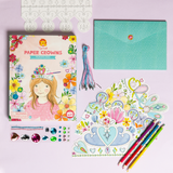 Craft kit with paper crowns, decorative elements, and colored pencils on a light purple background
