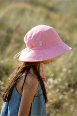Child wearing a pink sun hat in a natural setting