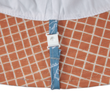 Close-up of underside of hat fabric with a grid pattern and a blue tag.