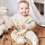 Baby sitting on floor playing with SPEEDY MONKEY Bead Maze