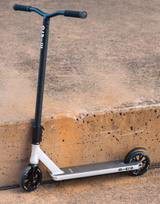 Micro scooter leaning against a concrete wall