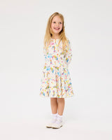 Girl wearing ROCK YOUR BABY UNICORN FLAGS LONG SLEEVE WAISTED DRESS