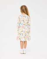 Back view of girl wearing ROCK YOUR BABY UNICORN FLAGS LONG SLEEVE WAISTED DRESS