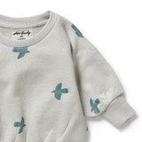 Detail view of ribbed neckline and sleeve cuff and bird print