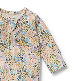 Detailed view of neck covered zip opening on WILSON & FRENCHY Tiny Bloom Organic Zipsuit With Feet