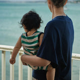 Person holding a child by the water