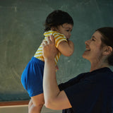 Woman holding a child in front of a chalkboard