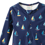 Navy blue baby swimsuit with sailboat pattern on a white background
