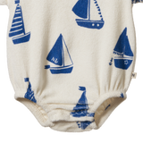 Baby romper with blue sailboat pattern on a white background