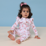 Child wearing a floral onesie against a blue background