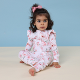 Baby wearing a floral onesie against a blue background