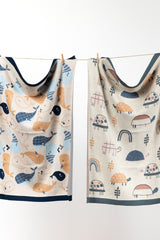 INDUS DESIGN Tilly Turtle Baby Blanket and Wilbur Whale Baby Blanket hanging on a string