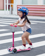 Child riding the MICRO SCOOTERS Mini Micro Deluxe LED - Pink