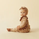Side view of baby wearing WILSON + FRENCHY Fawn Organic Ruffle Top