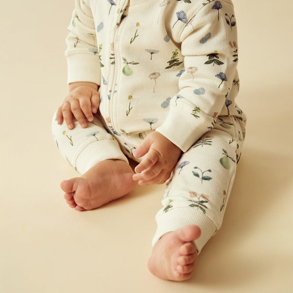 Baby wearing WILSON + FRENCHY Petit Garden Organic Zipsuit with Feet detail view of leg cuff