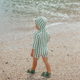 Child at beach wearing CRYWOLF Beach Sandal - Coastal Green and matching rash suit and legionnaire in coastal stripe