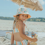 Child sitting at beach wearing CRYWOLF Bikini - Summer Stripe and matching reversible bucket hat - back view