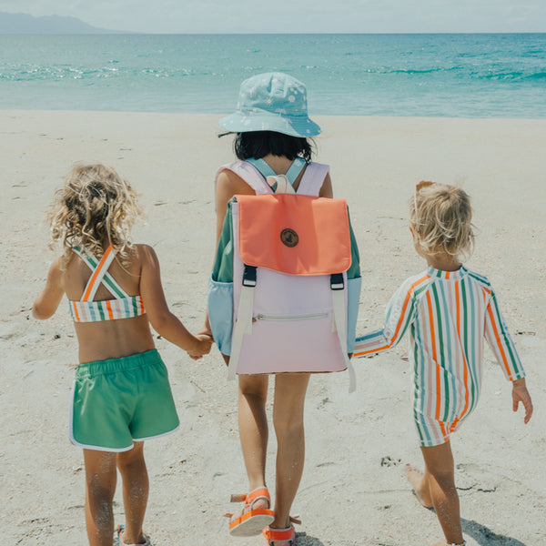 3 kids on beach with child in middle wearing the CRYWOLF Knapsack - Sunset Colour Block