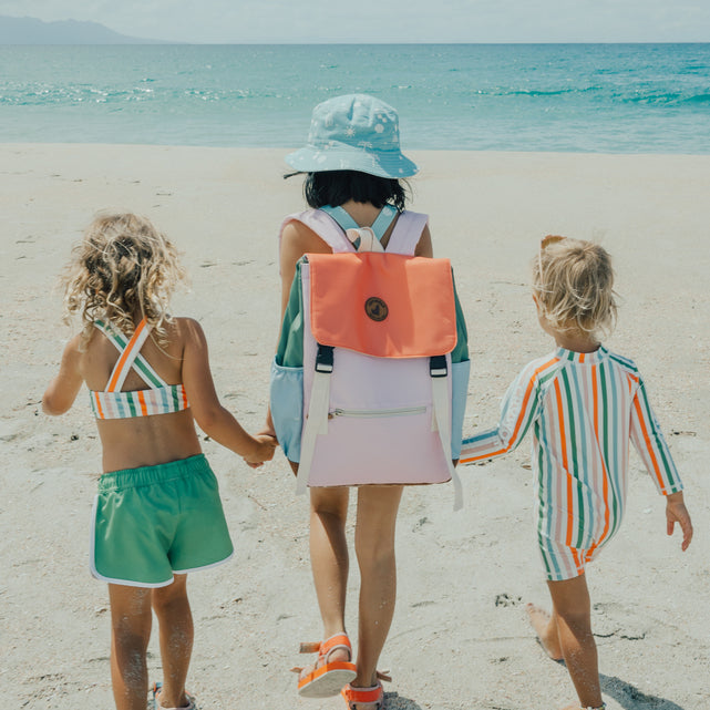 3 kids on beach with child in middle wearing the CRYWOLF Knapsack - Sunset Colour Block