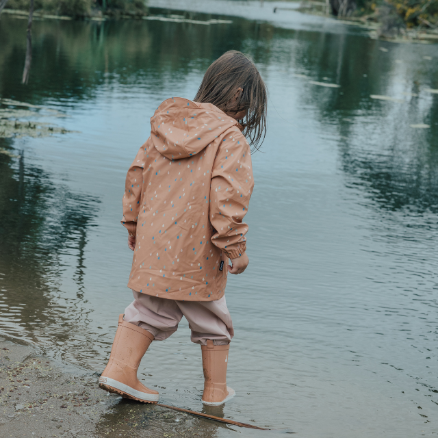 Back view of child wearing CRYWOLF Play Jacket Rain Drops, Dusty Pink Rain Overalls and Terracotta Rain Boots 
