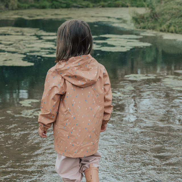 BacBack view of child wearing CRYWOLF Play Jacket Rain Drops, Dusty Pink Rain Overalls and Terracotta Rain Boots 