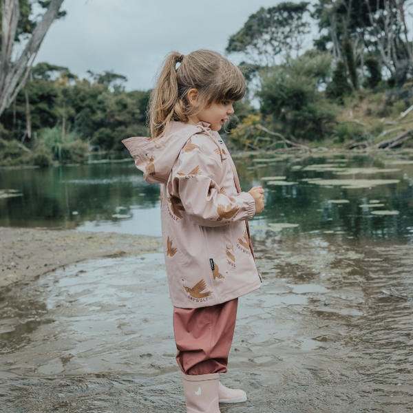 Side view of child wearing CRYWOLF Play Jacket Tui, Rosewood Rain Overalls and Dusty Pink Rain Boots